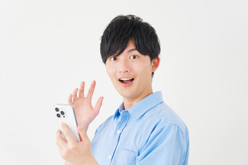 スマートフォンを持って驚く男性　白背景　カメラ目線