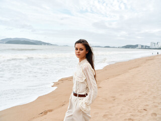 Beautiful young lady at the beach, enjoying summer vacation and the freedom of the sea.