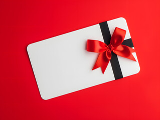 Blank white gift card with red ribbon bow isolated on red background. Minimal mockup 3D rendering. Gift and celebration concept for design, banner, and print. Flat lay composition with copy space