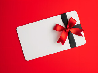 Blank white gift card with red ribbon bow isolated on red background. Minimal mockup 3D rendering. Gift and celebration concept for design, banner, and print. Flat lay composition with copy space
