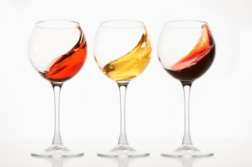 Rose, white, red wines splashes in stemware.