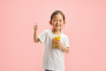 Happy Smiling Little Brunette Child Girl Drinking Orange Juice From Glass, Expresses Pleasure...