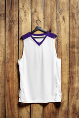 Basketball jersey on hanger against wooden background