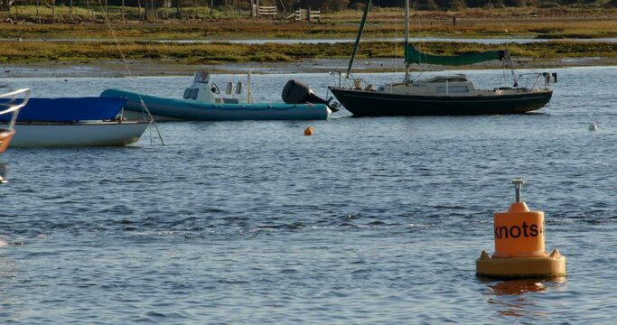 small motor yacht sailing out to sea on Lymington River