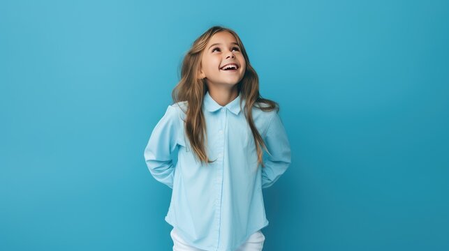 Portrait of a cute little girl smiling on a blue background.Portrait of a beautiful girl, a schoolgirl. The concept of advertising.