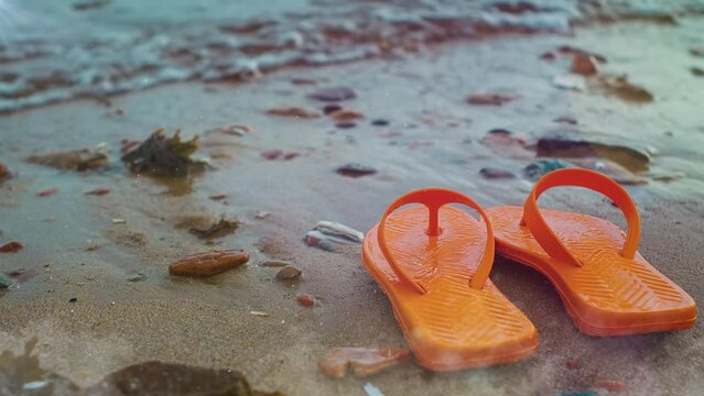 orange flip flops on beach. seamless looping overlay 4k virtual video animation background