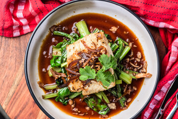 A serve of Grilled Rockling, served with asian greens and soy sauce.