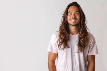 Fototapeta premium A man with long hair and smiling is wearing a t-shirt in front of a white background