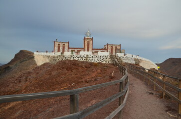 Punta La Entallada - active lighthouse on the Canary island of Fuerteventura during sunrise near the Atlantic Ocean. Medieval lighthouse on a rocky cliff of the volcanic island of Fuerteventura.