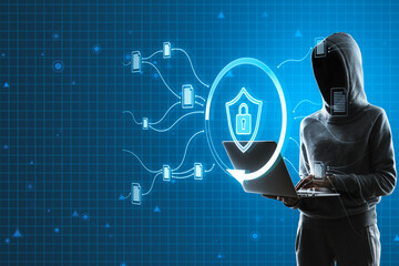 Hacker using laptop with glowing padlock shield hologram on blurry blue background. Safety, hacking, web protection and antivirus concept.