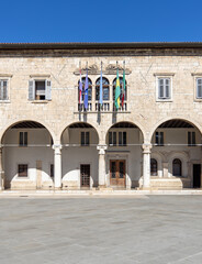 Fototapeta na wymiar Pula, Croatia, Istria - September 29, 2023: Facade of Communal Palace located on the Forum Square. It is seat of local government