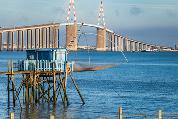 View of a fishery on the banks of the Loire. In the background, the bridge of Saint-Nazaire, the longest in France.