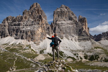 Stunning view of a tourist enjoying the view of the Tre Cime Di Lavaredo, Dolomites, Italy.
