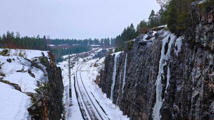 Obraz premium Railroad tracks in a wintry landscape between two mountains