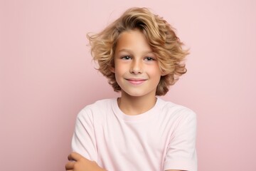 Portrait of a cute little girl with blond curly hair on a pink background