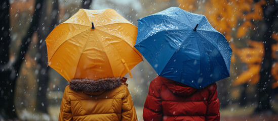 two people holding umbrellas in the snow