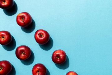 Many red apples on colored background, top view. Autumn pattern with fresh apple above view