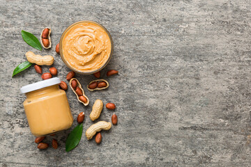 Bowl of peanut butter and peanuts on table background. top view with copy space. Creamy peanut...