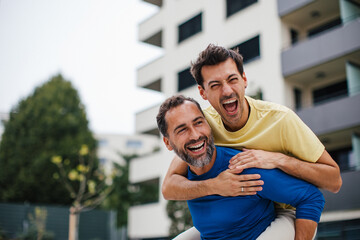 Best friends playing sport outdoors, having fun. Celebratin goal, carrying friend on back, piggyback. Concept of male friendship, bromance.