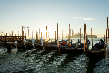 Venedig, Gondeln im Morgenlicht , liegen in der Lagune vor der Insel San Giorgio Maggiore mit dem Kloster des Heiligen Georg.