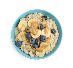 Tasty oatmeal with banana, blueberries and peanut butter in bowl isolated on white, top view