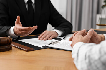 Senior man having meeting with lawyer in office, closeup