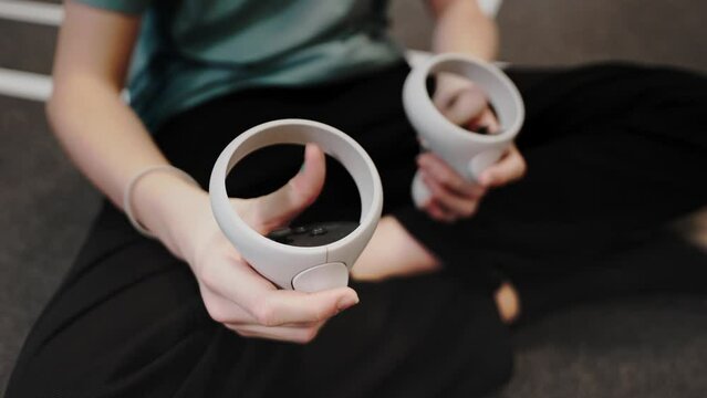 Close-up of the controller in the hand to the virtual reality headset. Kids are playing VR shooters at the club.