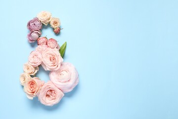 8 March greeting card design made with beautiful flowers on light blue background, top view. Space for text