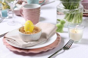 Festive table setting with painted egg in decorative nest. Easter celebration