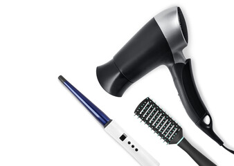 Hair dryer, round brush and curling iron on white background, top view