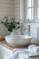 Elegant white bathroom sink with a modern faucet and rolled towels