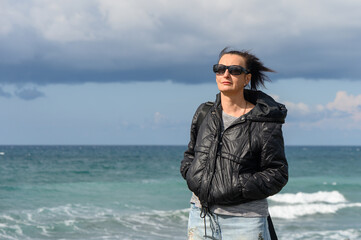 woman in a black jacket on the shores of the Mediterranean sea 2