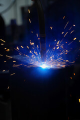 Industrial robots are welding in a car body factory,Welding robots assemble automotive parts in a...