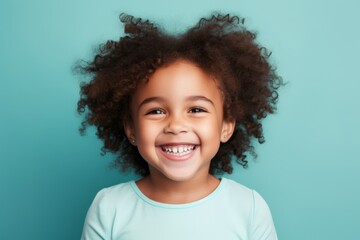 Happy african american little girl with curly hair on blue background