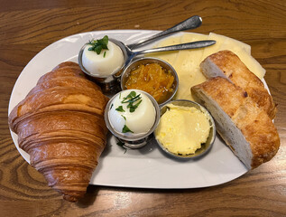 French breakfast. Buns and croissants with butter. Eggs.