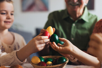 Grandparents and girl holding decorated easter eggs. Tradition of painting eggs with brush and easter egg dye.