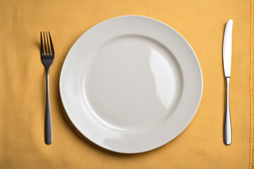 Top view on colored background empty round white plate on tablecloth for food