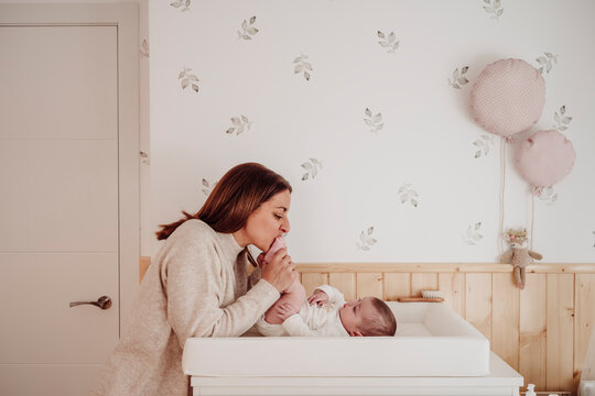 Mother kissing daughter's feet at home