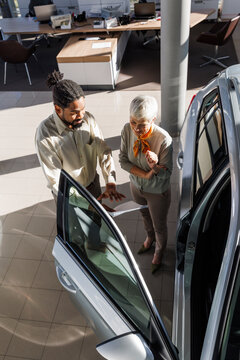 Car salesperson discussing over document with customer