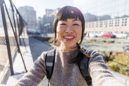 Happy woman taking selfie on sunny day