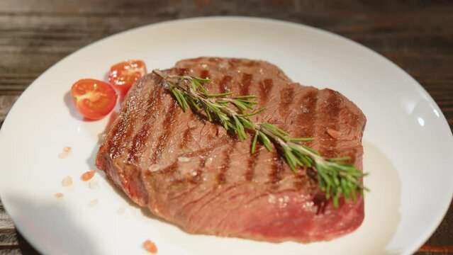 Serving grilled beef steak medium rare doneness close-up.