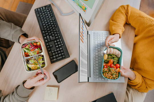 Freelancers working and having lunch at table