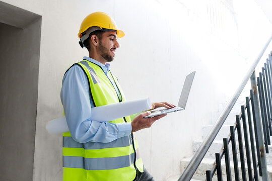 Architect using laptop on steps at site