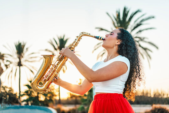 Passionate woman playing saxophone at skate park