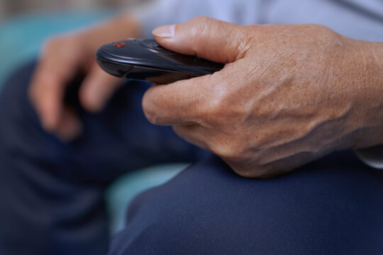 Senior man holding TV remote control