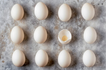 White shell eggs on a concrete countertop, in a row