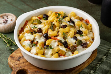 Oven baked pasta macaroni with vegetables, olives, zucchini, carrots and mozzarella cheese with thyme.