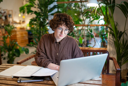 Botanist working on laptop at table in plant shop