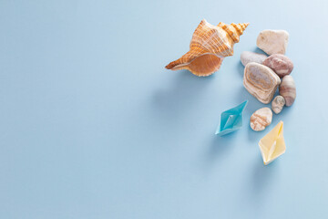 summer sea background with paper boats, stones and seashell