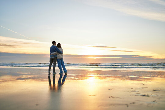 Young couple embracing at coastline on ocean beach